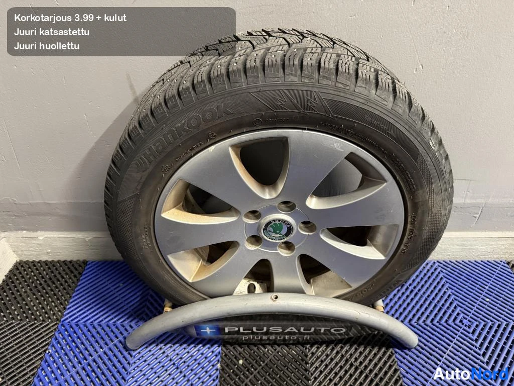 Yksityiskohta: Irrotettu rengas alumiinvanteella Skoda-emblemällä; renkaan sivuseinässä lukee Hankook.
