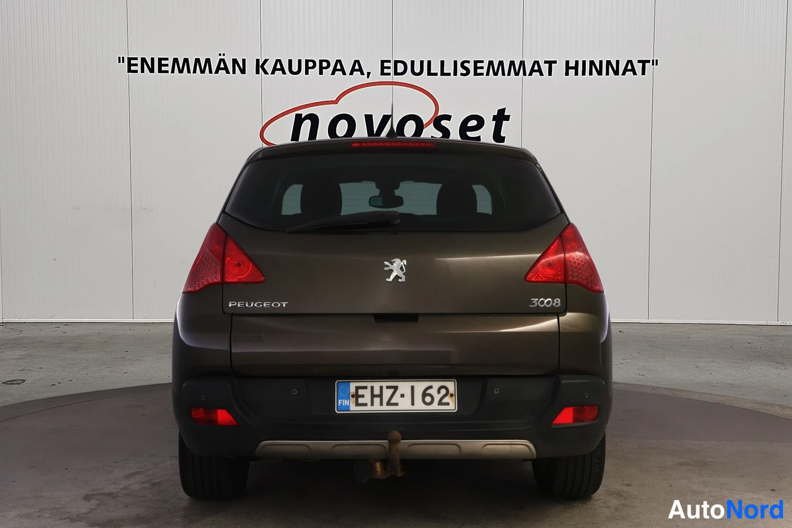 Takaa: Ruskean auton takaosa suoraan takaa, Peugeot-merkki, rekisteri.