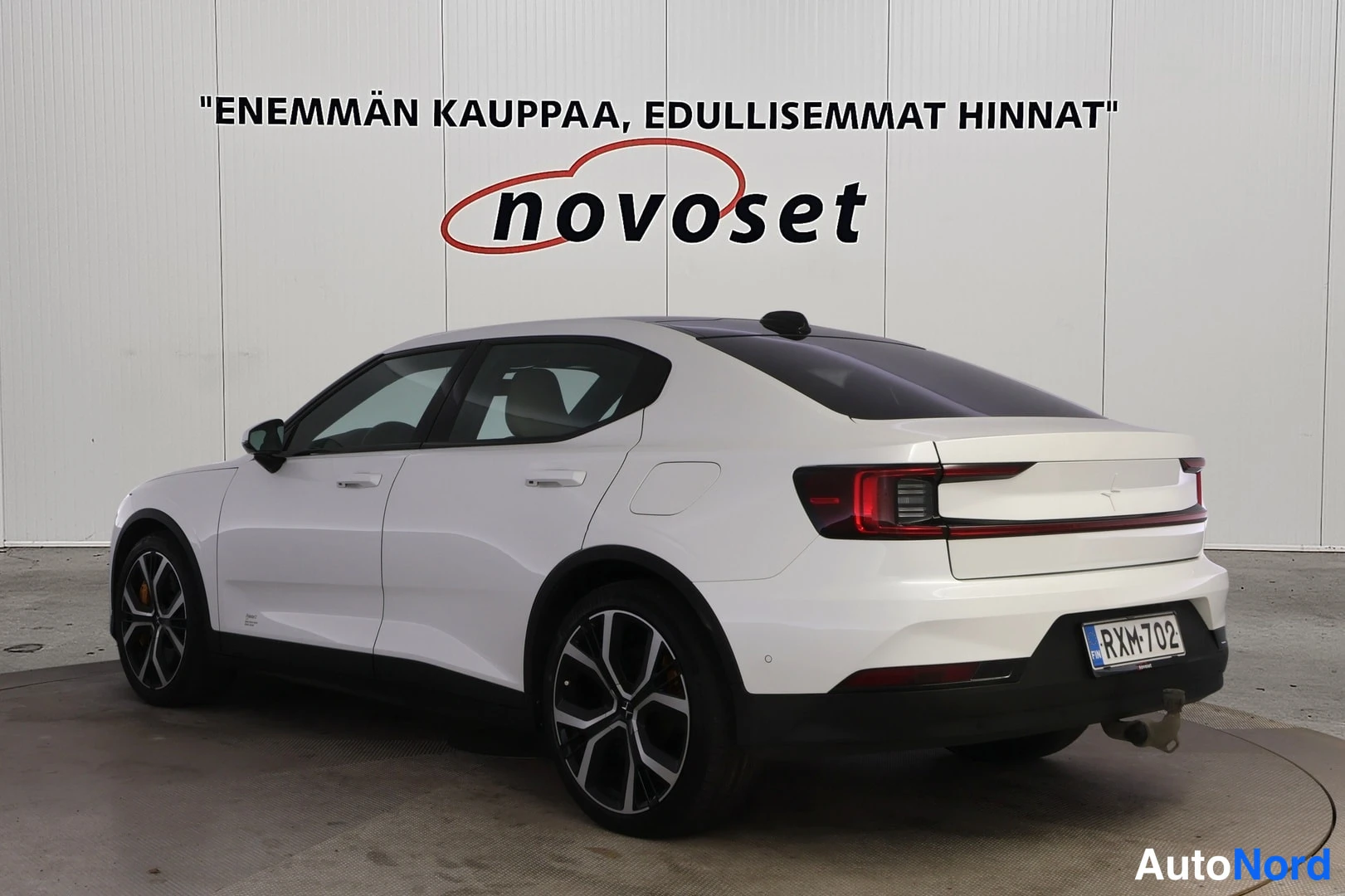 Takaviisto: Valkoinen Polestar 2 takavasemmalta, takavalot ja koukun aihe näkyvät.