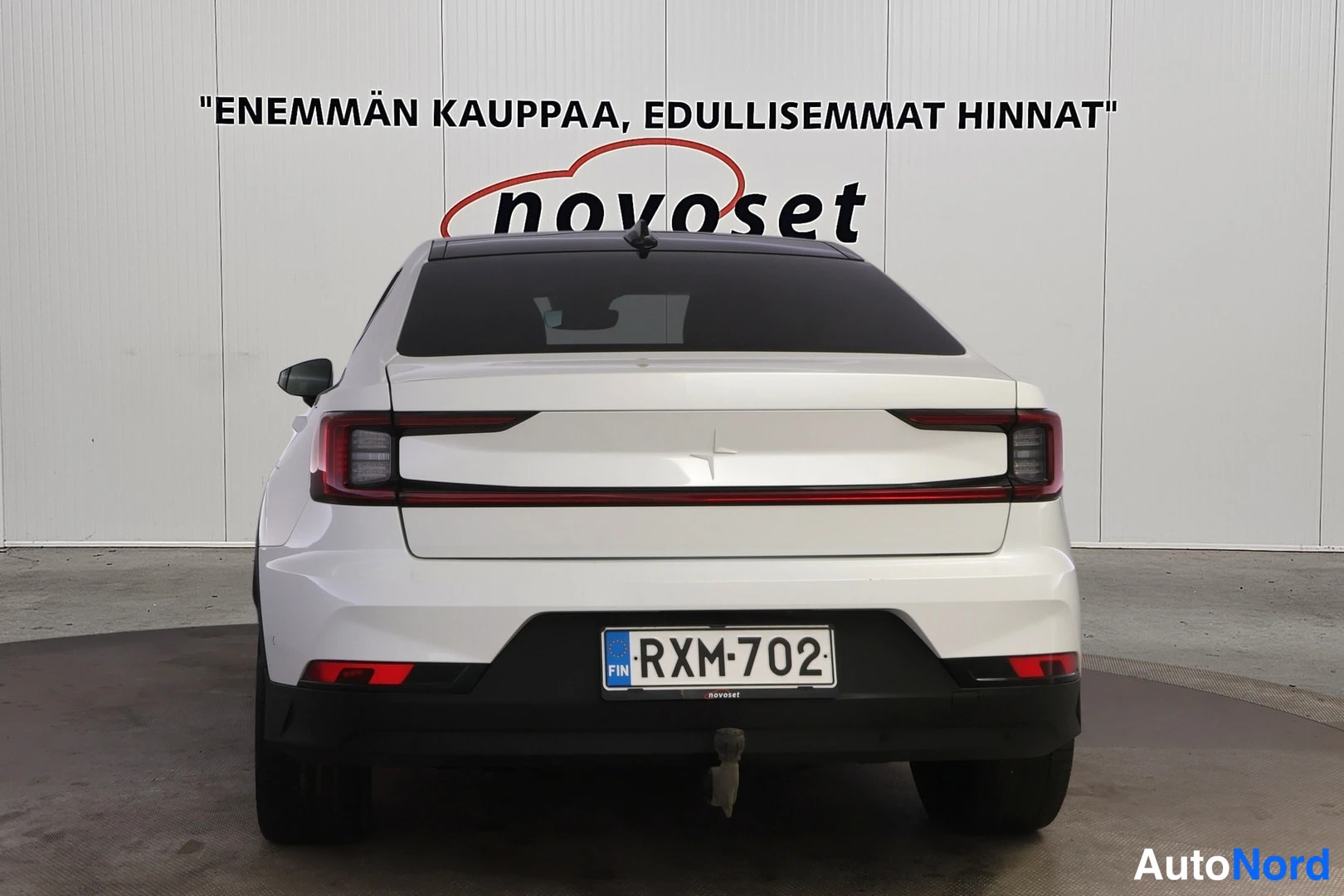 Takaa: Valkoinen Polestar 2 suoraan takaa, poikittainen takavalo ja rekisterikilpi näkyvät.