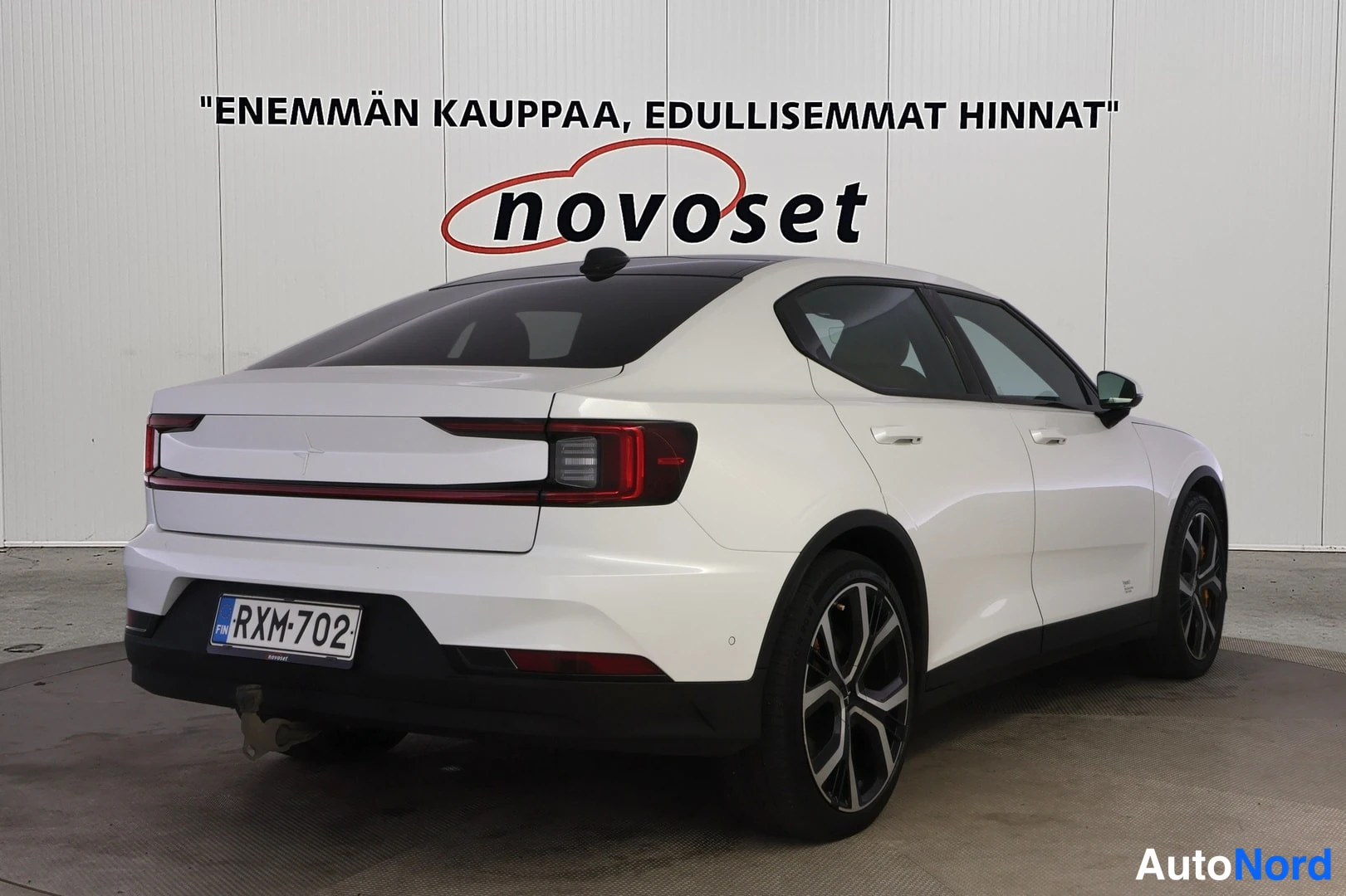 Takaviisto: Valkoinen Polestar 2 vinosti taka oikealta, takavalot ja mustat vanteet näkyvät.