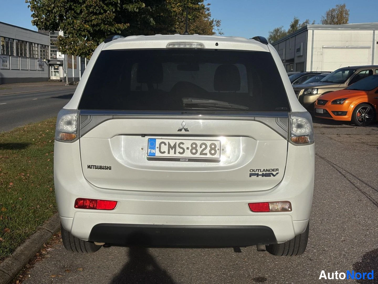 Takaa: Valkoisen Mitsubishi Outlander PHEV:n takaosa suoraan takaa, rekisterikilpi, takanäyttö tumma.