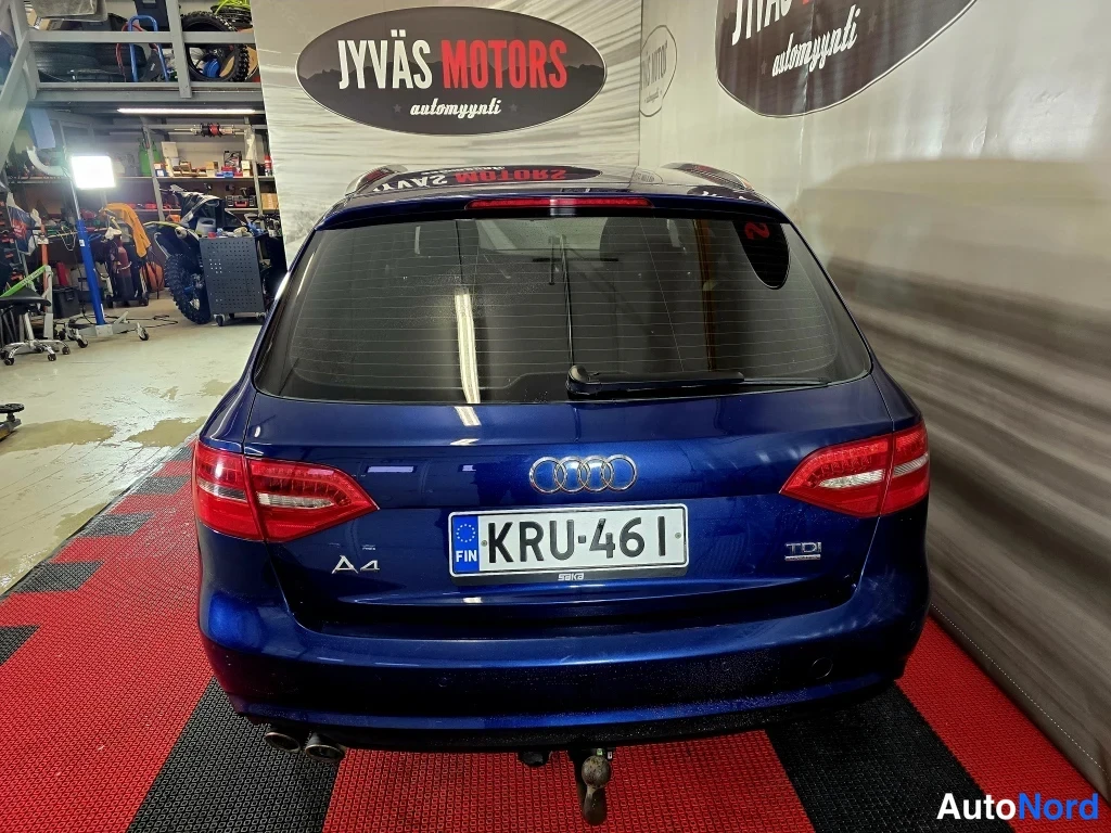 Takaa: Sininen Audi A4 Avant takaapäin kuvattuna, takavalo ja Audi-merkki näkyvät, rekisterikilpi.