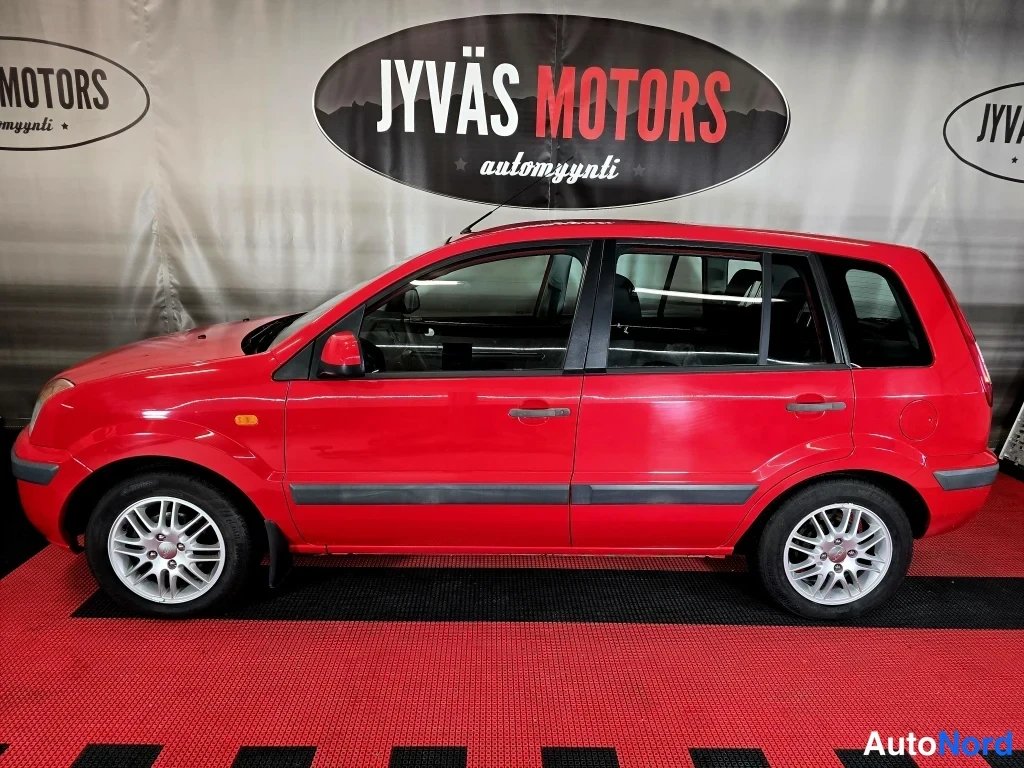 Sivulta: Punaisen Ford Fusion -auton sivuprofiili, auton vasen kylki näkyvissä kokonaan.