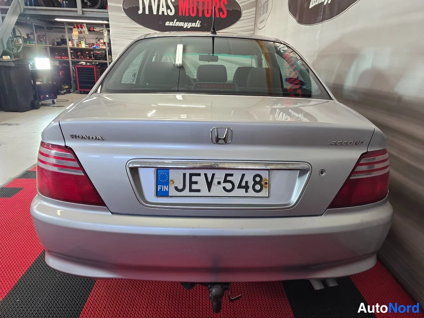 Takaa: Honda Accord -sedanin takaosa hallitilassa: rekisterikilpi, Honda- ja Accord-merkinnät, punaiset takavalot ja vetokoukku.