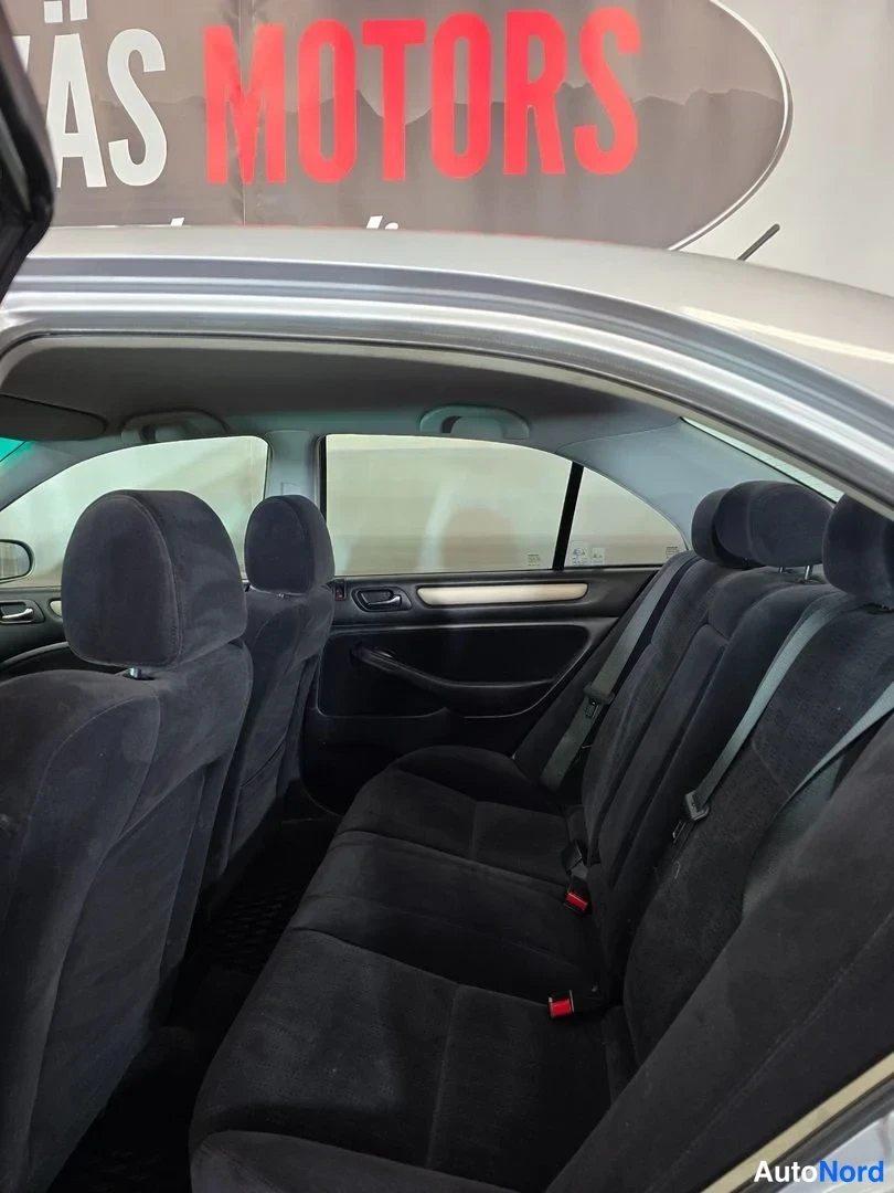 Muu: Honda Accordin takapenkit tummalla kangasverhoilulla kuvattuna avoimesta takaovesta.