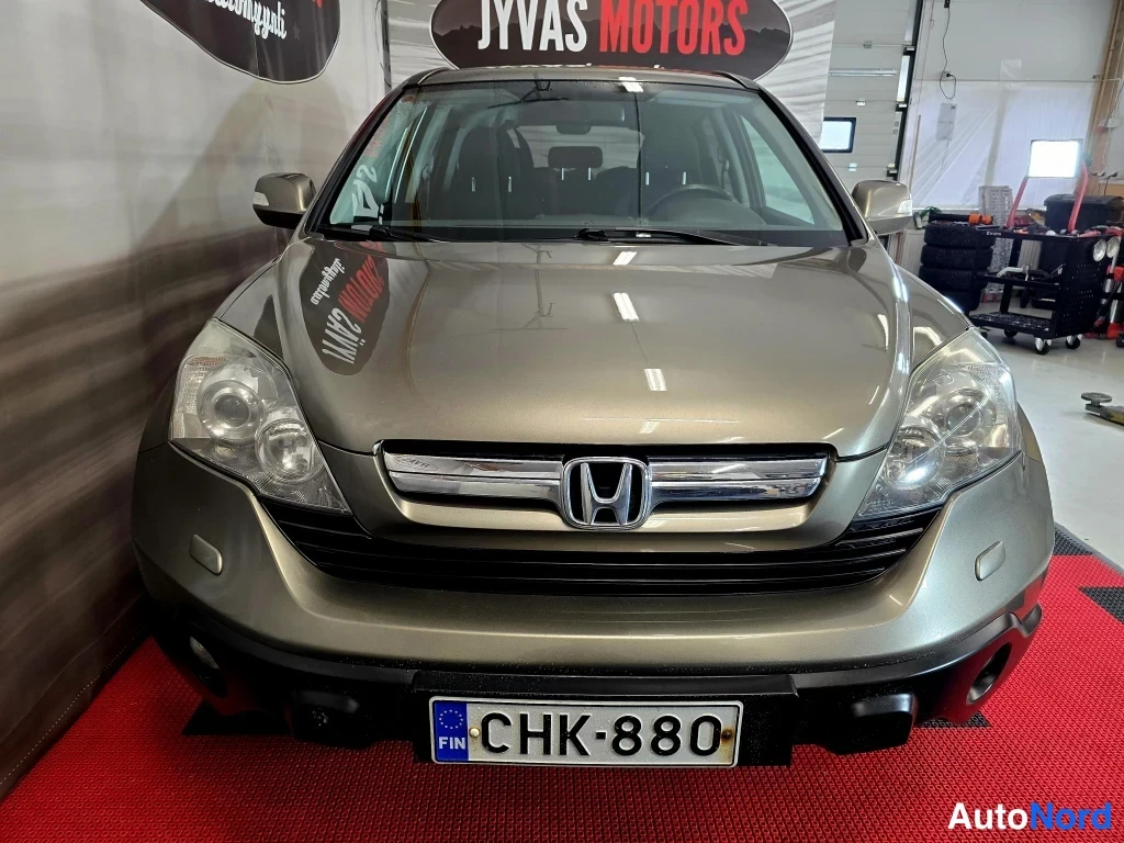 Edestä: Honda CR-V etupää edestä suoraan kuvattuna; kromiset etusäleikkö ja Honda-logo sekä rekisteritunnus näkyvät.