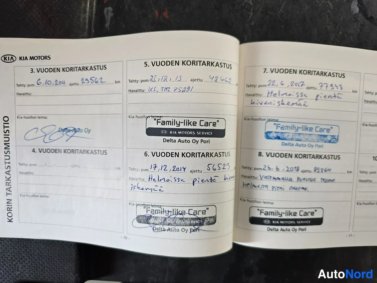 Muu: Kia Motorsin huolto- ja koritarkastusvihko avattuna, jossa käsinkirjoitettuja merkintöjä 3., 5., 6., 7. ja 8. vuoden koritarkastuksista.