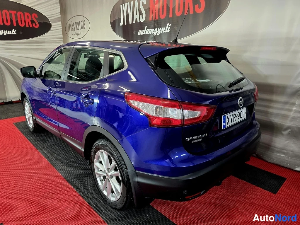 Takaviisto: Sininen Nissan Qashqai takaviisto; QASHQAI-teksti takaluukussa, tummansininen korikansi ja hopeavanteet näkyvät, rekisterikilpi.