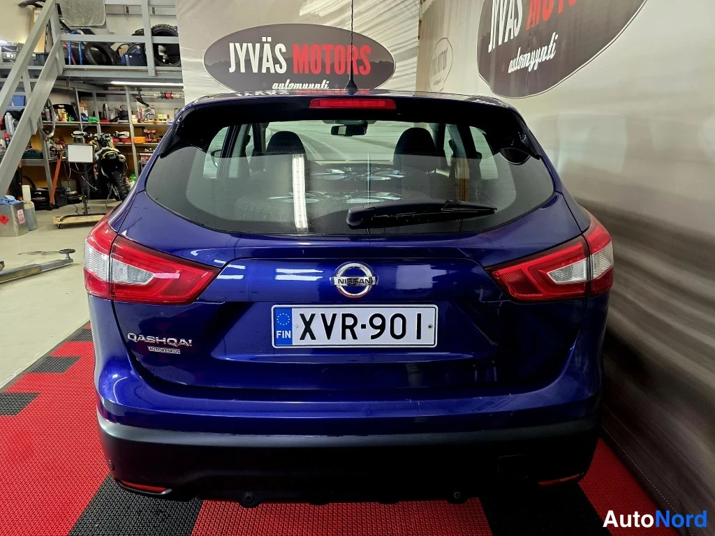 Takaa: Sininen Nissan Qashqai kuvattu suoraan takaa; takaluukussa NISSAN-merkki ja QASHQAI-teksti, rekisterikilpi, takavalo punaiset.