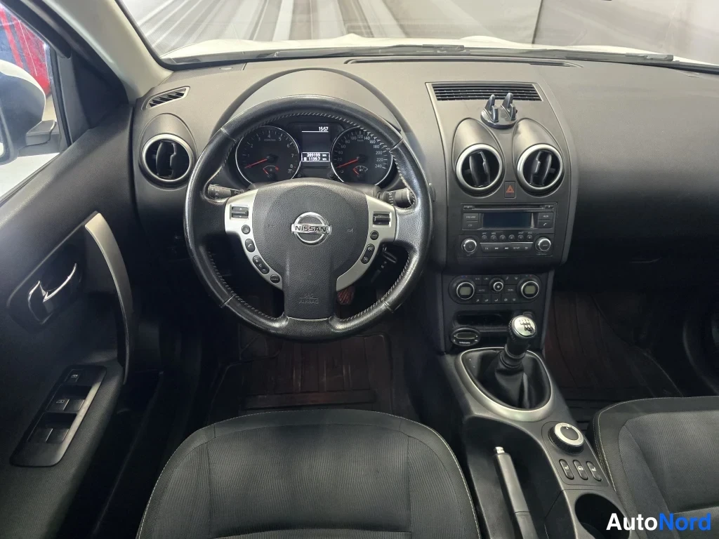 Muu: Ohjaamosta näkyy Nissan-ohjauspyörä, mittaristo ja manuaalivaihteiston vaihdekeppi.