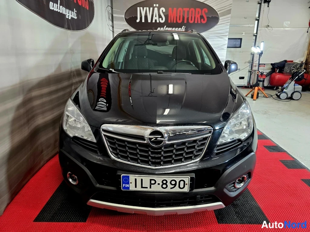 Edestä: Opel Mokka suoraan edestä kuvattuna, musta kori, Opel-emblem säleikössä ja rekisterikilpi.