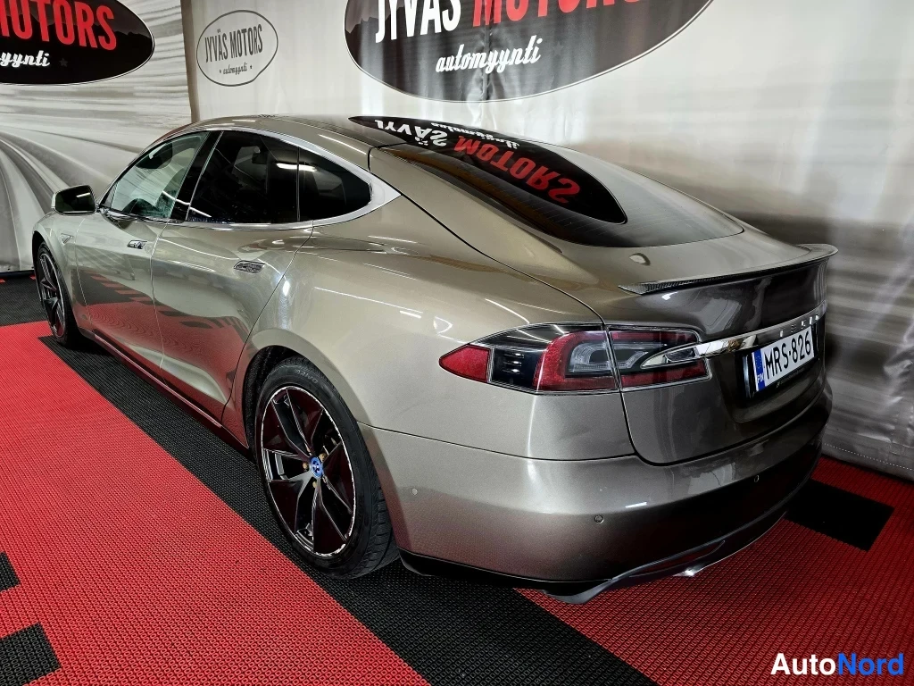 Takaviisto: Tesla Model S -sedanin takakulma; rekisterikilpi, tumma spoileri ja takavaloissa punainen elohopea-lasisuus.