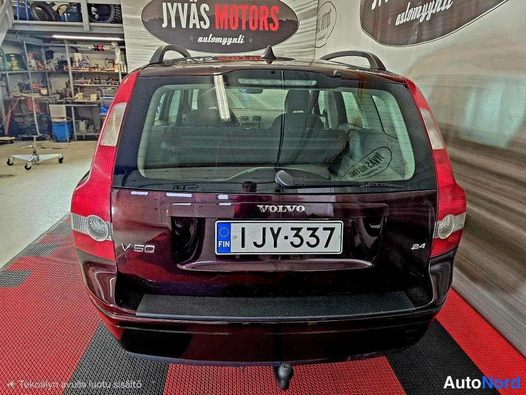 Takaa: Auton takaosa: rekisterikilpi, VOLVO-merkintä ja V50- ja 2,4-embleemit.