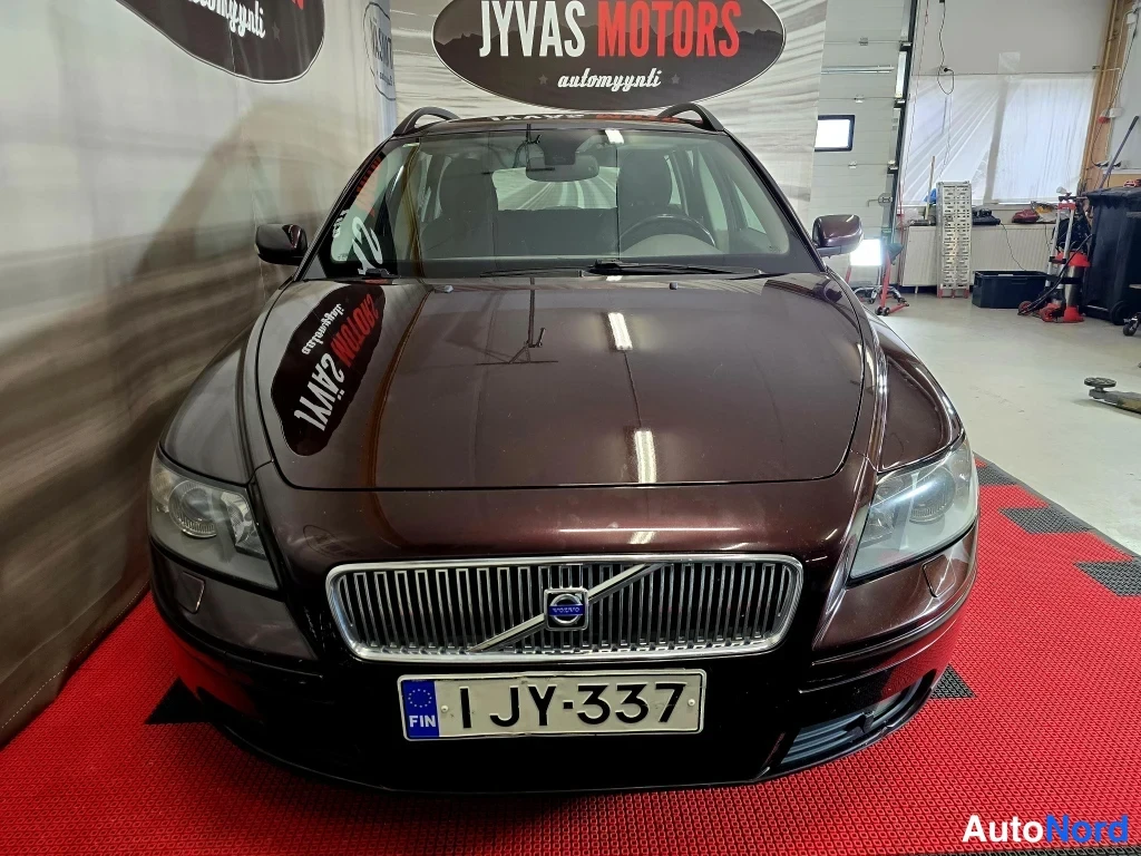 Edestä: Volvo V50 farmari etukatselissa tummanpunaisena, konepelti ja etusäleikön Cavalokko näkyvät, rekisterikilpi JY-337.