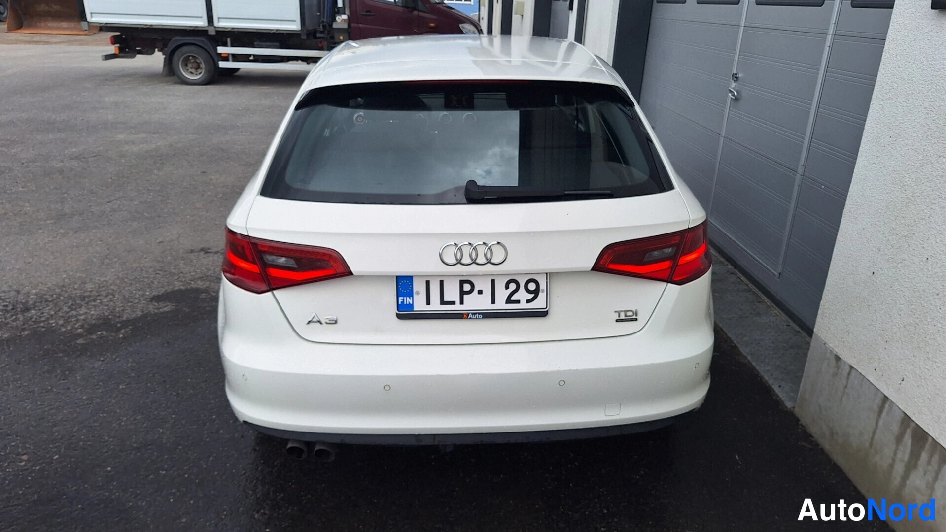 Takaa: Audi A3:n takaosa suoraan takaa; valkoinen koripinta, punaiset takavalot ja rekisteritunnus.