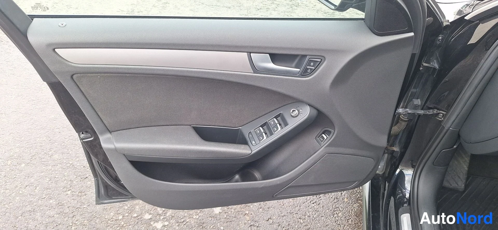 Muu: Audi-nelospöörän kuljettajan oven sisäpinta avoimena, jossa ikkunakytkimet ja kahva näkyvät.