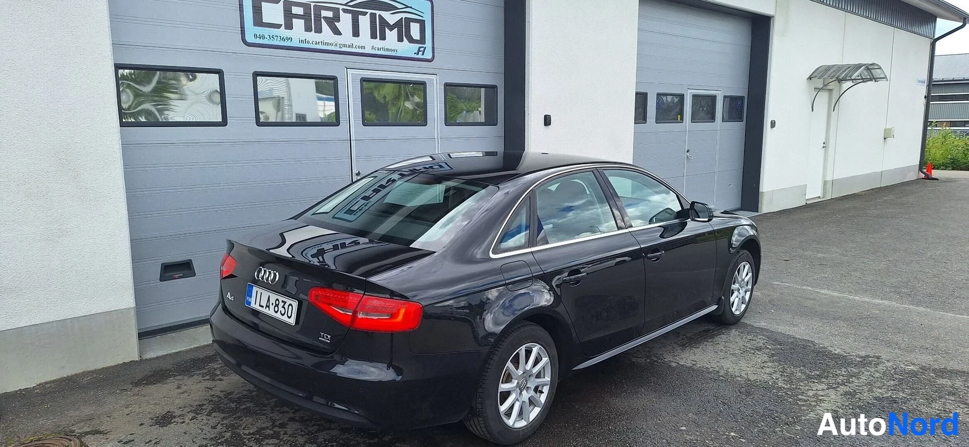 Takaviisto: Audi A4 -sedanin takakulmakuva: musta runko, punaiset takavalot, Audi-merkki ja takapuskurin poistoputki näkyvät.