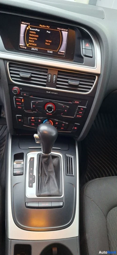 Muu: Audi A5:n kojelaudan keskusta: radio-näyttö, ilmastointipaneeli (22,0 °C), automaattivaihteen valitsin P-R-N-D-S-asemilla.