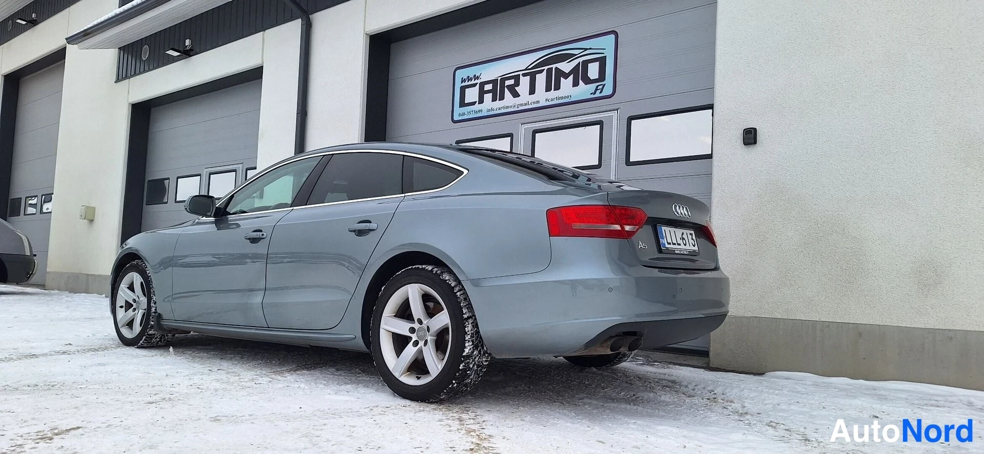 Takaviisto: Audi A5 Sportbackin takaosa ja vasen kylki talviparkissa Cartimon hallin edessä