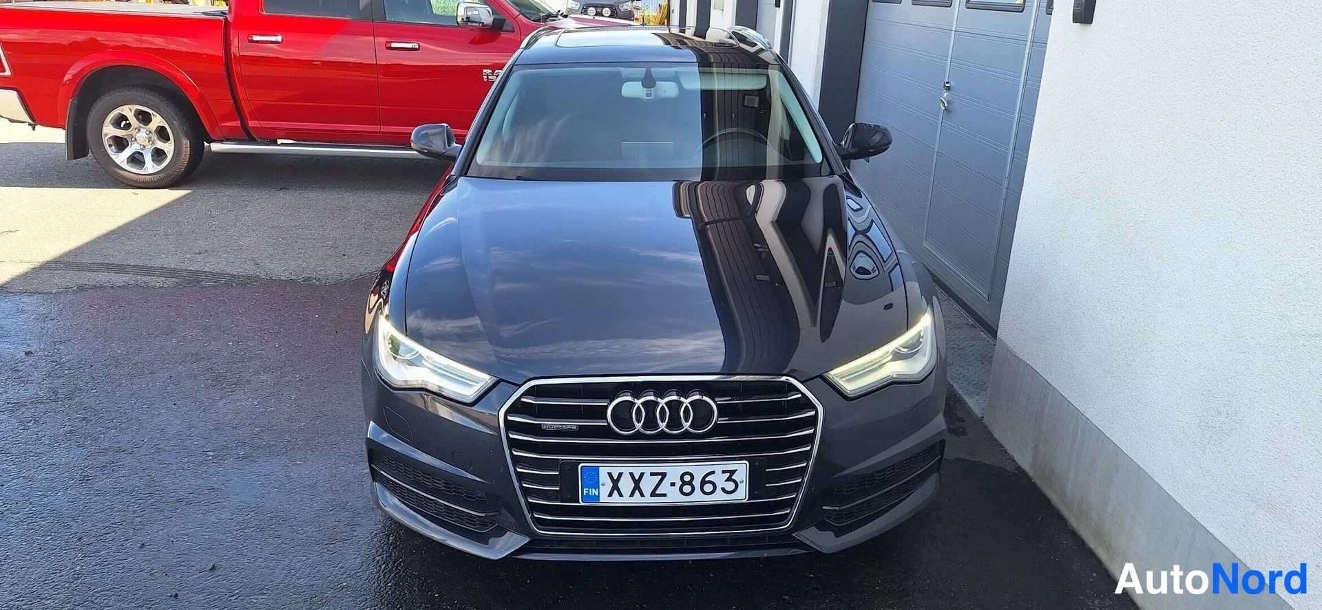Edestä: Audi A6 Avant -farmari tummansinisenä edestä kuvattuna, rekisteritunnus.