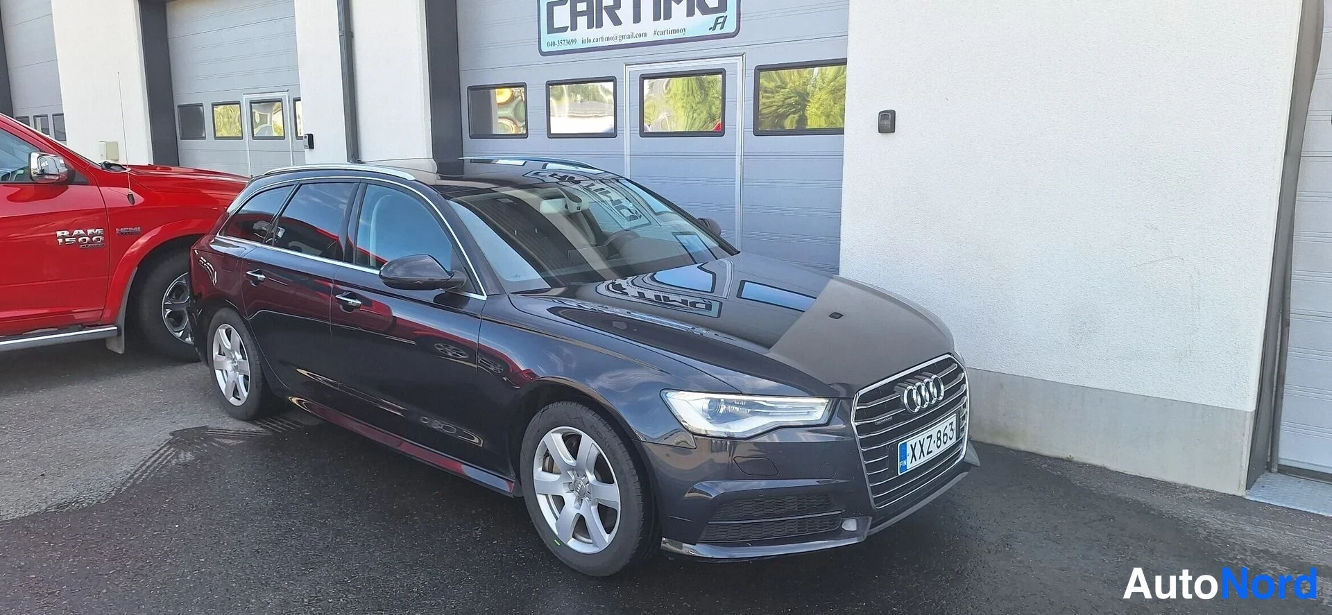 Etuviisto, nokka oikealle: Audi A6 -farmari tummansinisenä edestä oikealta kuvattuna