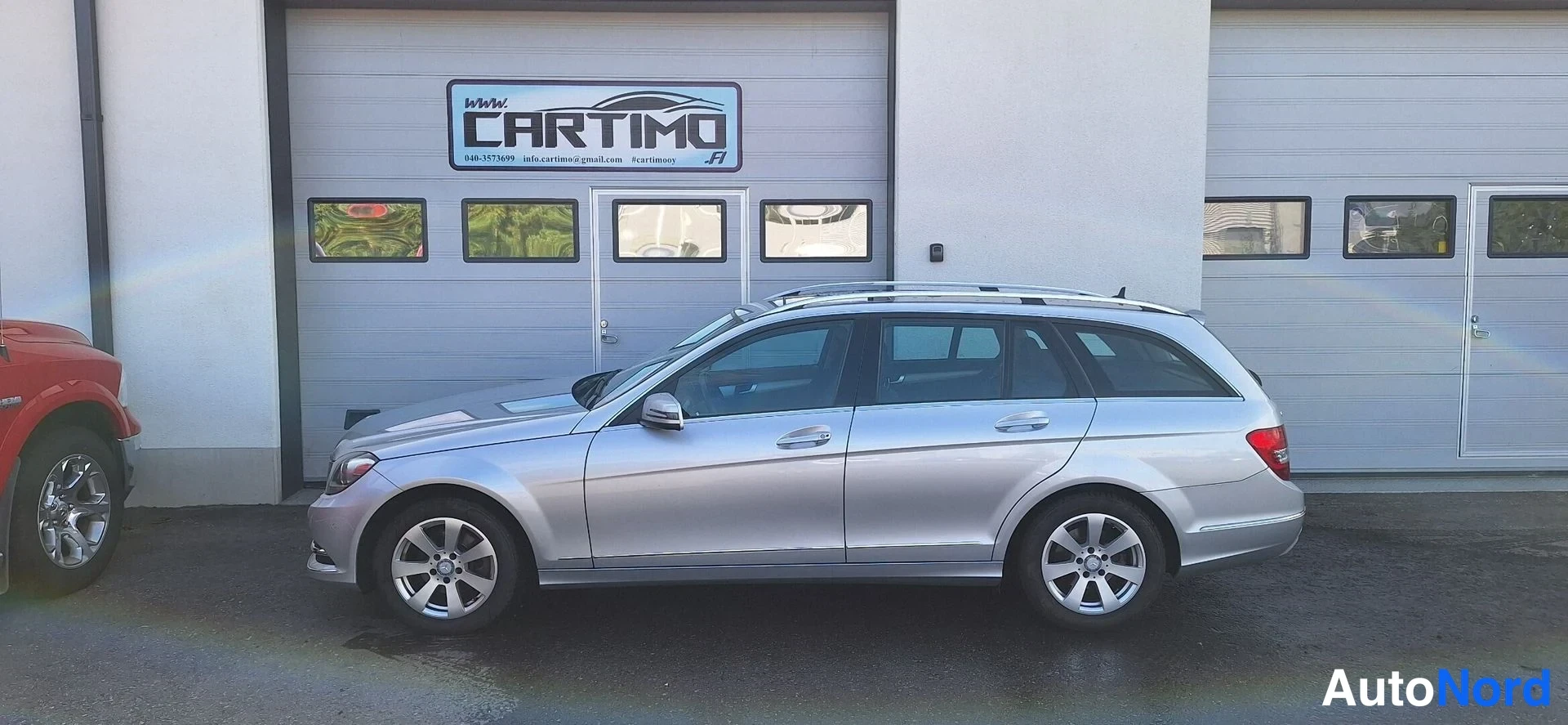 Sivulta: Hopeanharmaa farmariauto sivusta valvonnan parked autotallin ovella.