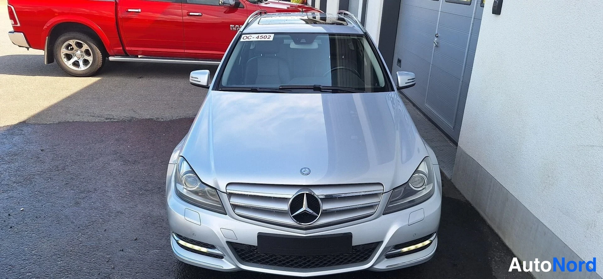 Edestä: Hopeaisen Mercedes-Benz C -farmarin etupää etukaarista, tunnus OC-4502 tuulilasissa.