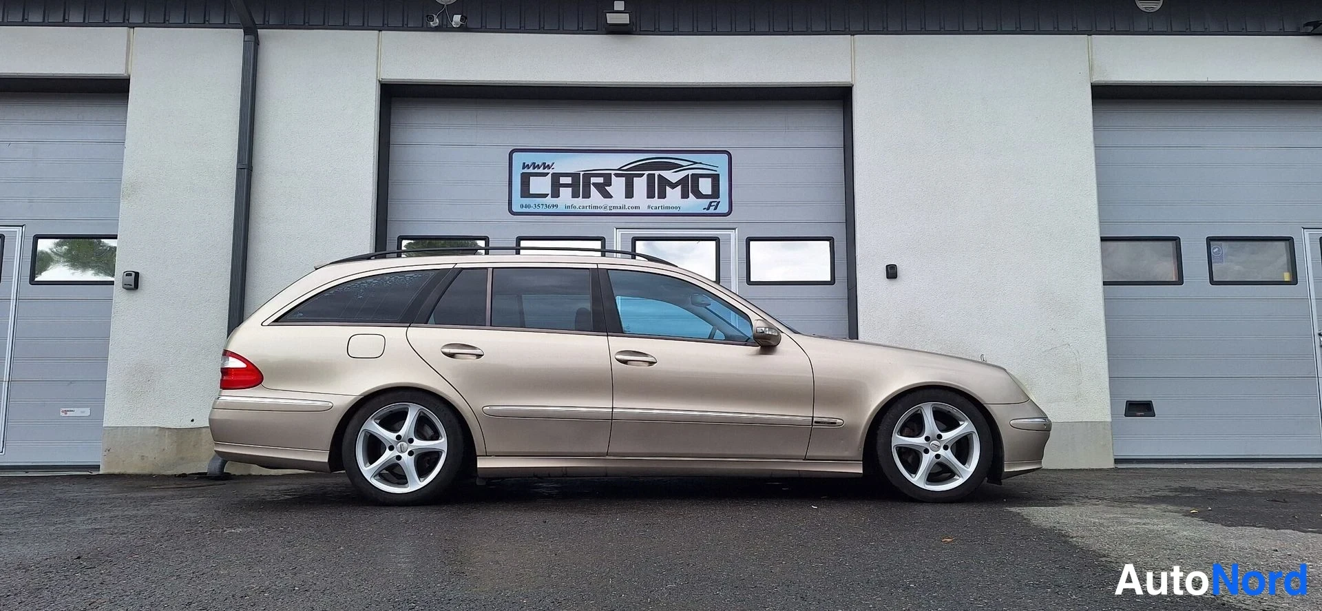 Sivulta: Mercedes-Benz E-farmarin sivukuva, vaaleanbeige koripinta ja hopeat monimutkaiset vanteet.