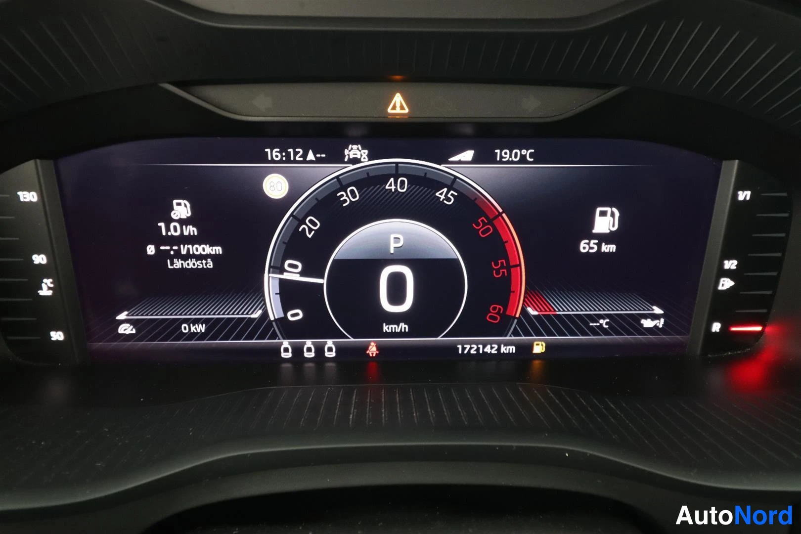 Yksityiskohta: Digitaalinen mittaristö: nopeus 0 km/h, vaihde P, lukemat 172142 km, polttoaine 65 km ja 19.0 °C.