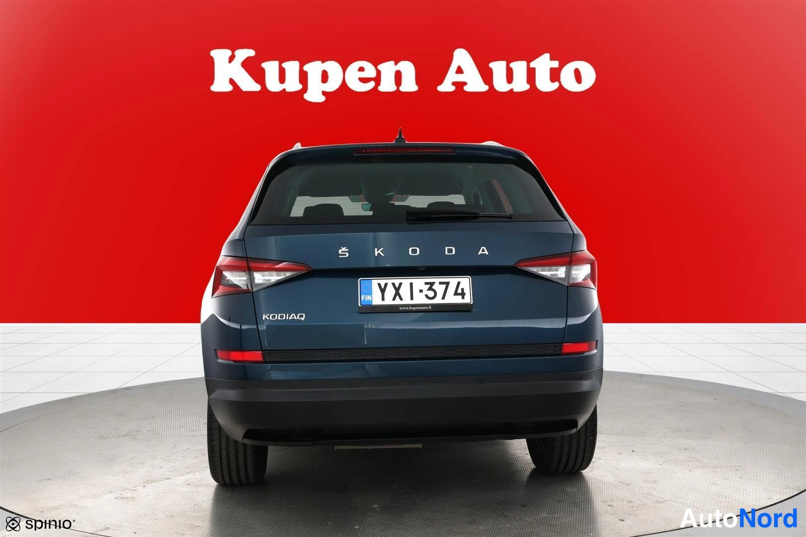 Takaa: Sininen Skoda Kodiaq takaa kuvattuna punaisella taustalla, rekisteritunnus.