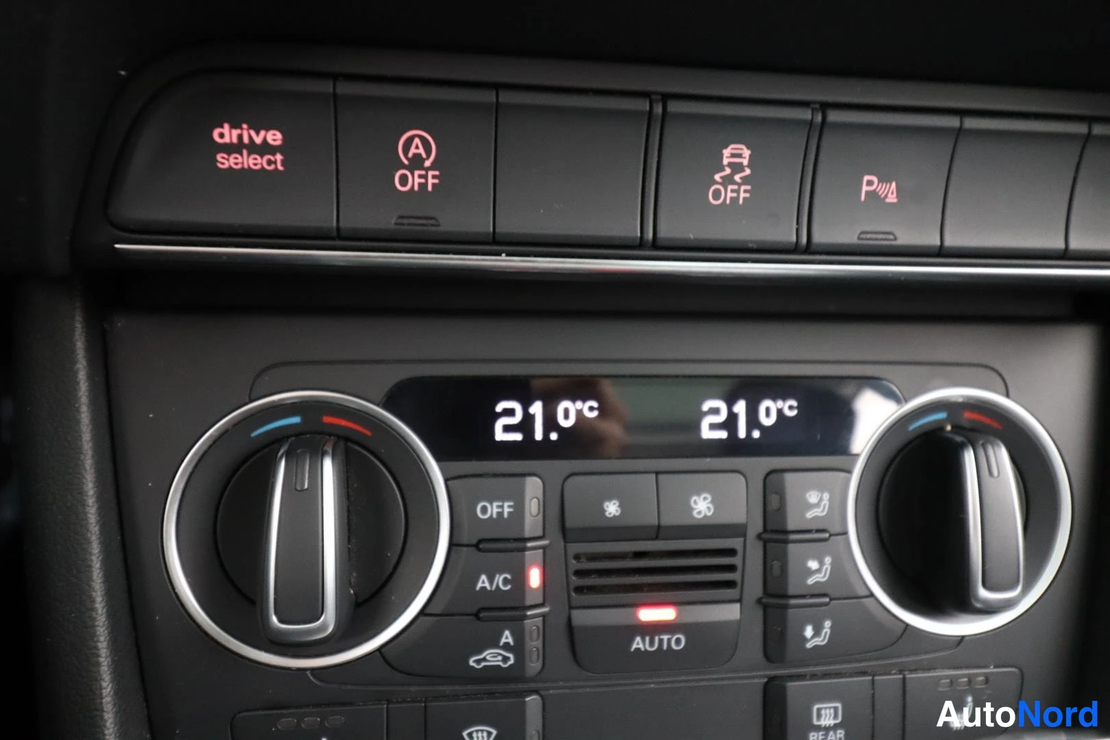 Yksityiskohta: Audi Q3:n keskikäyttöpaneelin kiinniotto: drive select -painike, kääntyvien ajovalojen ja ESP:n OFF-kytkimet, pysäköintianturin P-symboli sekä kaksivyöhykkeen a