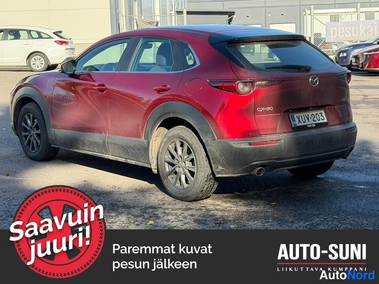Takaviisto: Punainen Mazda CX-30 taka-kolmannesnäkymässä, perä kuvan oikealla; takavalot, CX-30-merkki ja rekisterikilpi näkyvät.