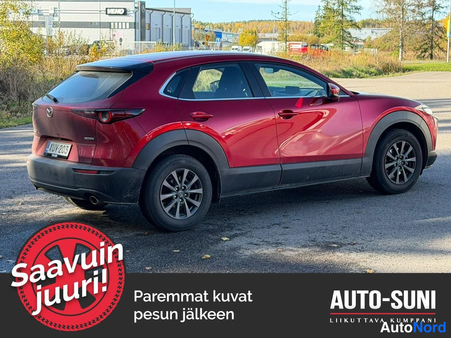 Takaviisto: Punainen Mazda CX-30 taka-kolmannesnäkymässä, perä kuvan vasemmalla; takavalot, rekisterikilpi ja oikea kylki näkyvät.