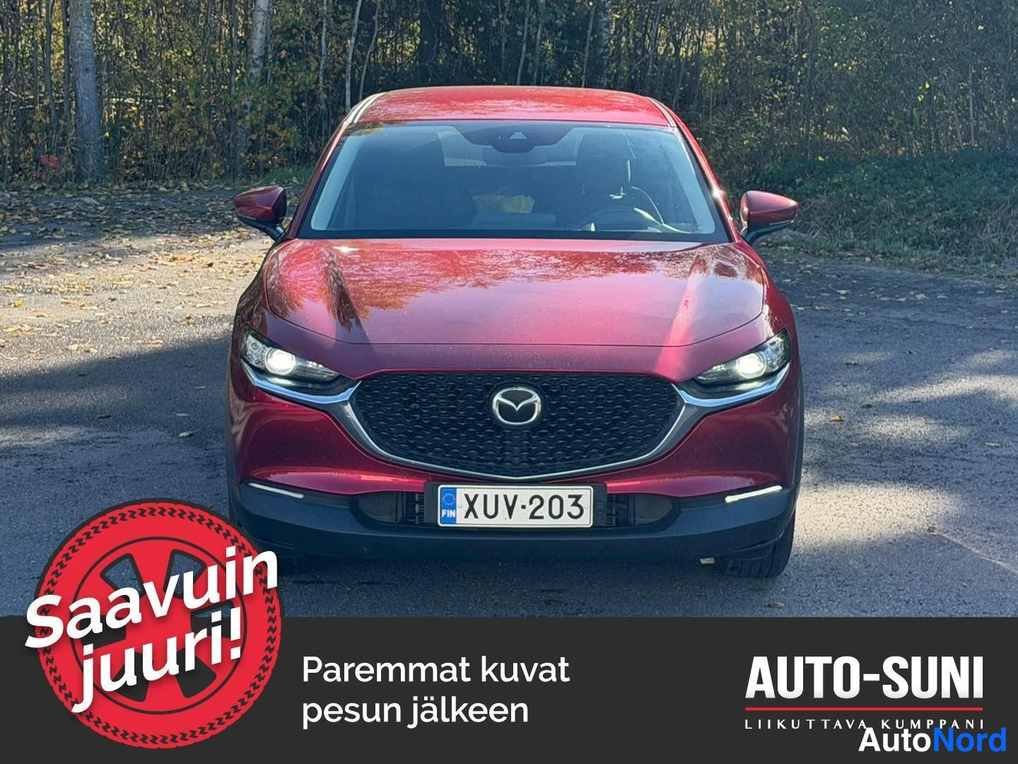 Edestä: Punainen Mazda CX-30 suoraan edestä kuvattuna: etusäleikössä Mazda-merkki, ajovalot päällä, rekisterikilpi.