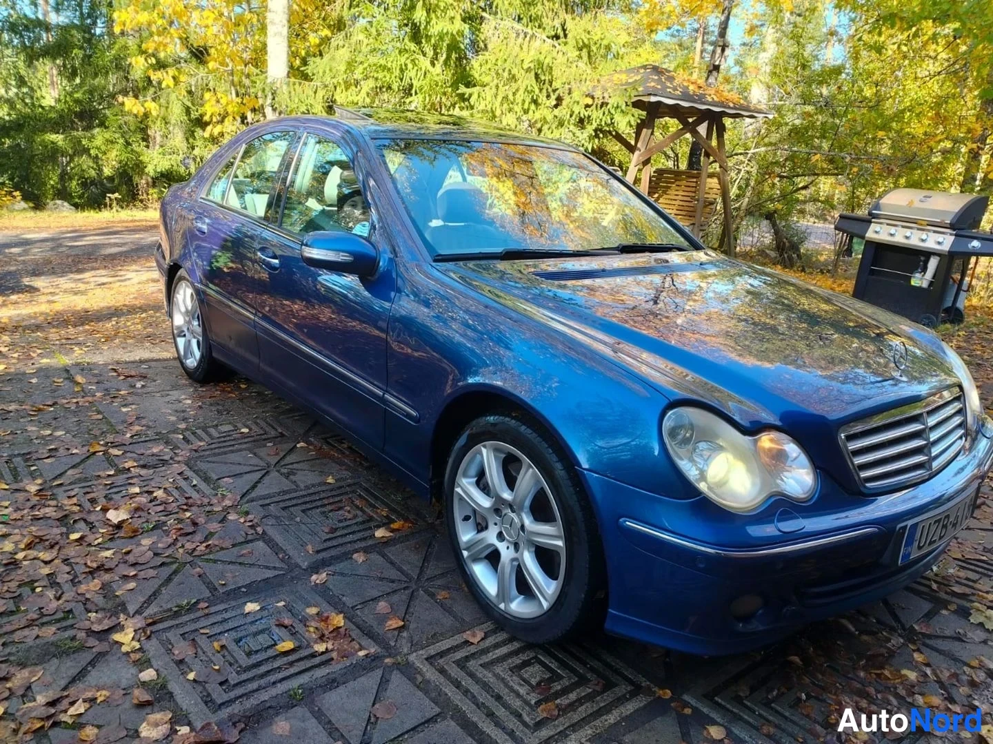 Etuviisto, nokka oikealle: Tummansininen Mercedes-Benz-sedan etunurkasta oikealta kuvattuna; etusäleikkö, valot ja kylki näkyvät.