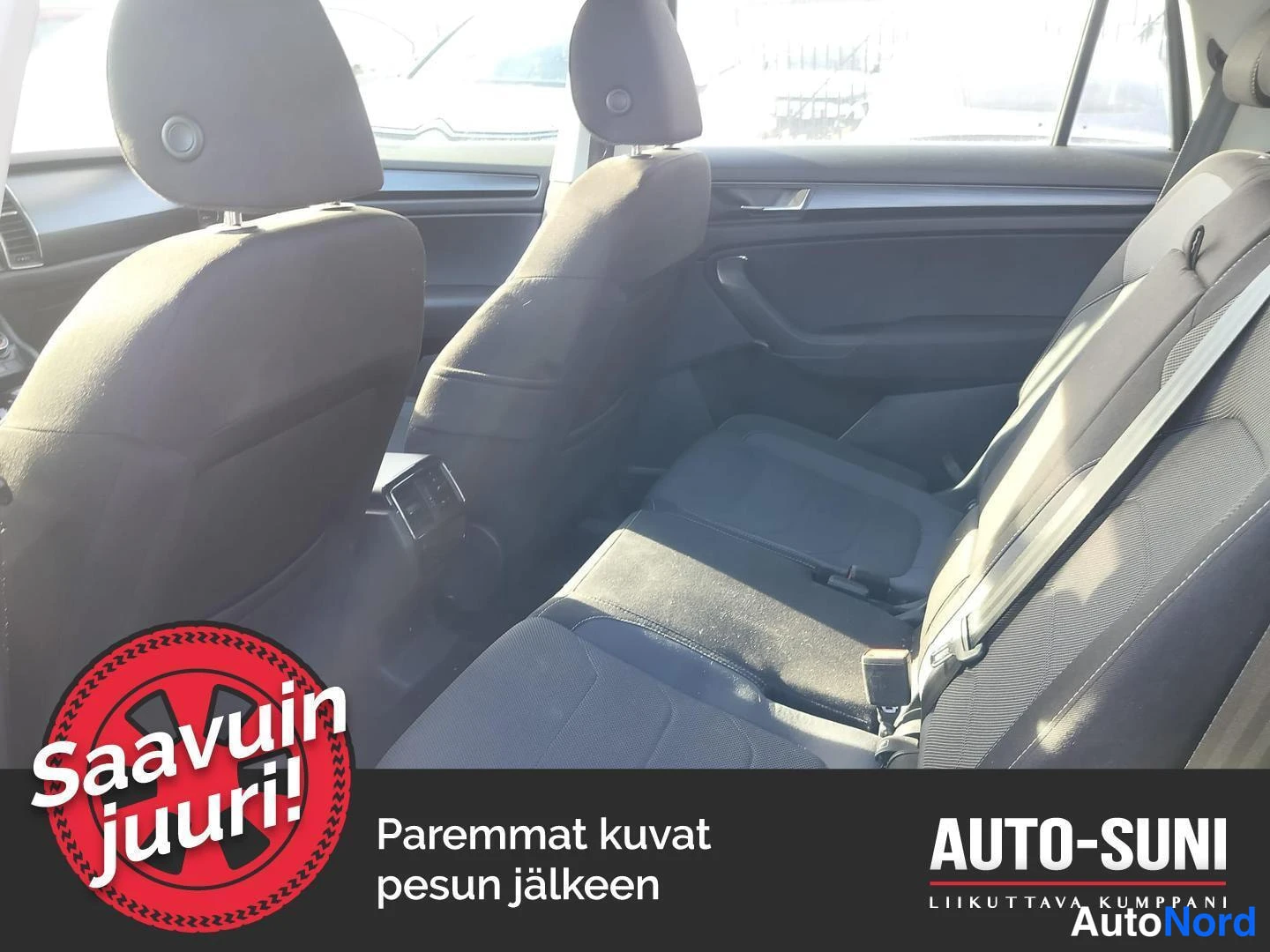 Muu: Auton takaistuimien yleiskuva takaoven suunnasta: tummat kankitakapenkit, kolme niskatukea, takaoven sisäpaneeli ja keskinäisen konsolin takapuoli.