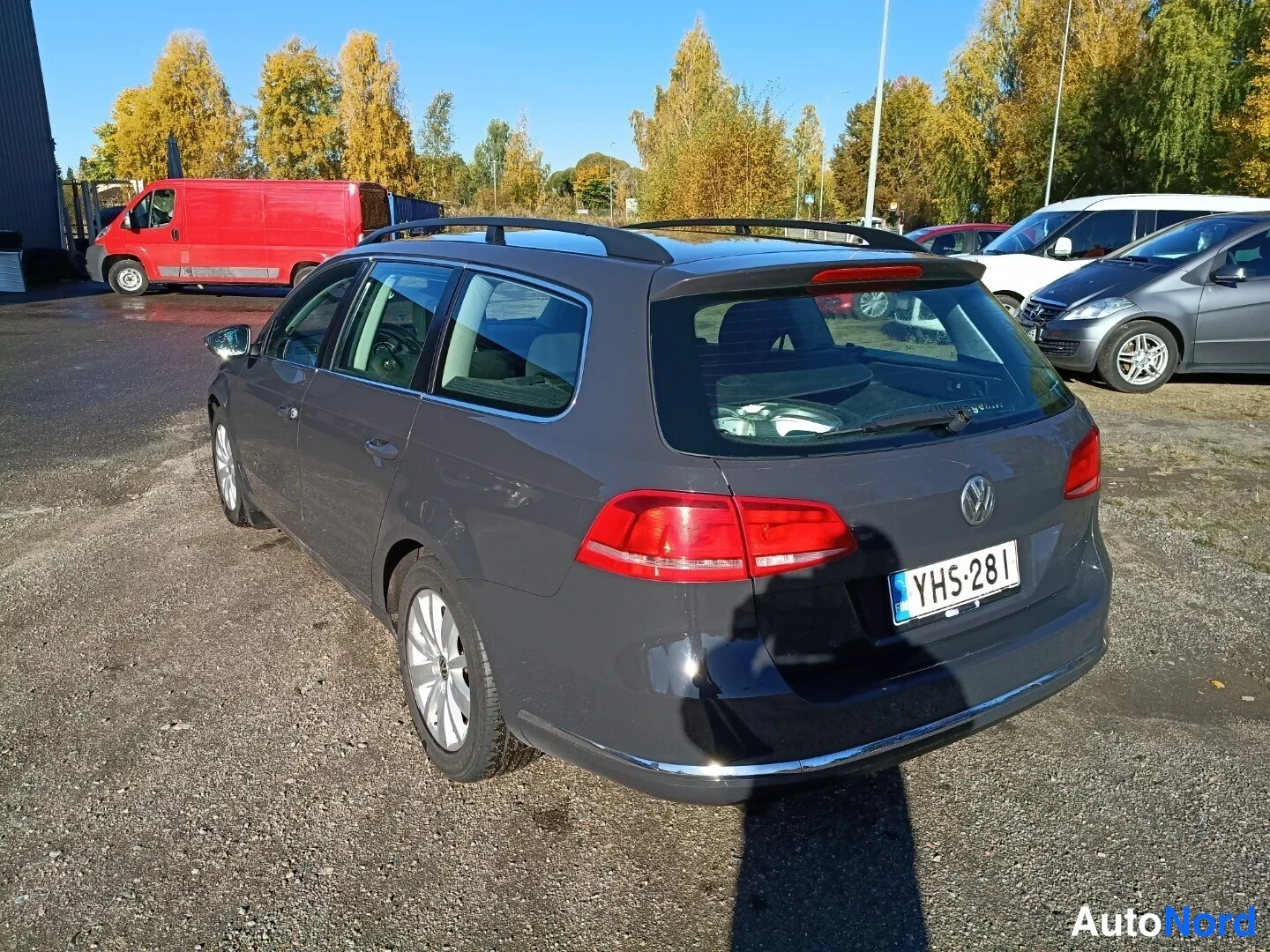 Takaviisto: Volkswagen Passat -farmari takaa oikealta kolmantenvartta kuvattuna, tummanharmaa kori, rekisterikilpi.
