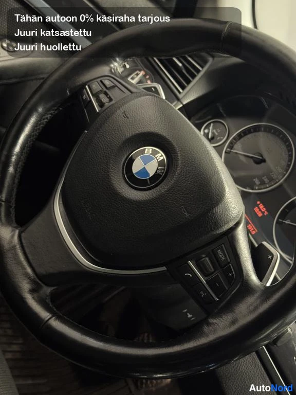 Yksityiskohta: BMW-merkillä varustettu ohjauspyörä ja kojelaudan mittarit lähikuvassa.