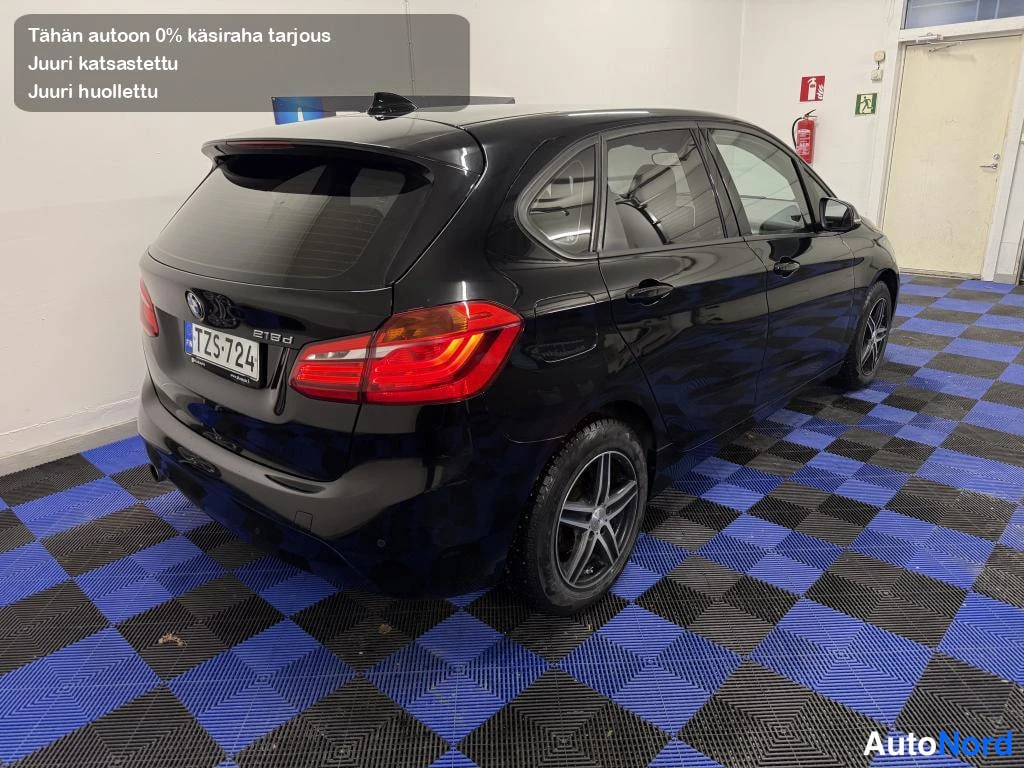 Takaviisto: Musta hatchback-auto takaa kulmasta kuvattuna sisätiloissa, takavalot ja rekisterikilpi näkyvissä.