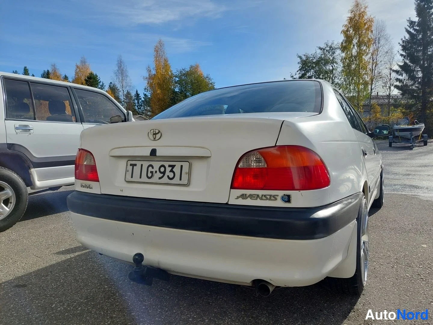 Takaa: Valkoisen sedan perä takaa, rekisteritunnus, Avensis-merkki ja vetokoukku