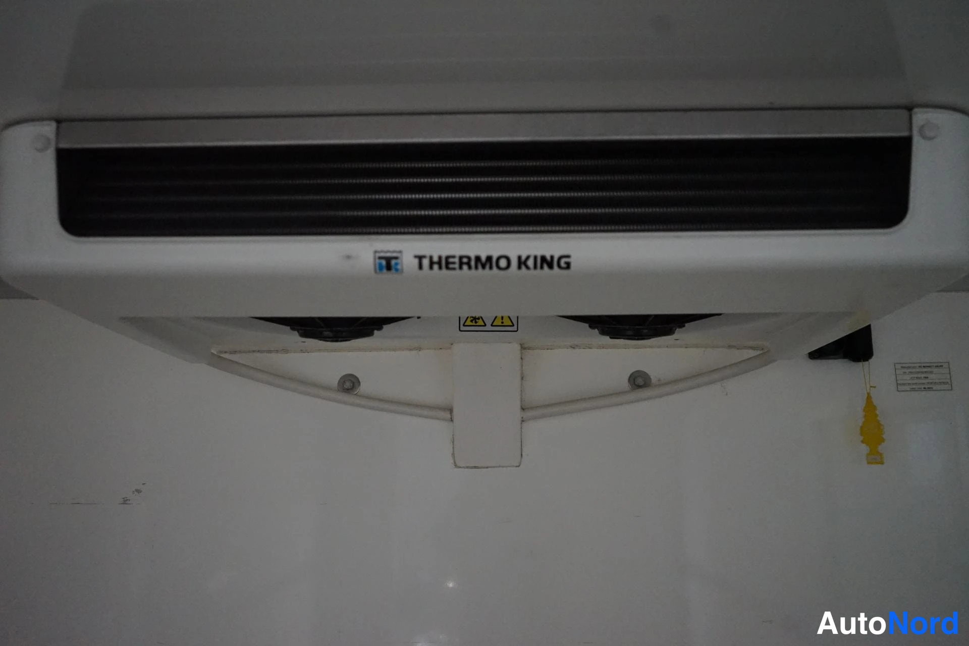 Edestä: Lähikuva lavan katossa olevasta Thermo King -jäähdytysyksiköstä; yksikön etupaneelissa luettavissa teksti THERMO KING.