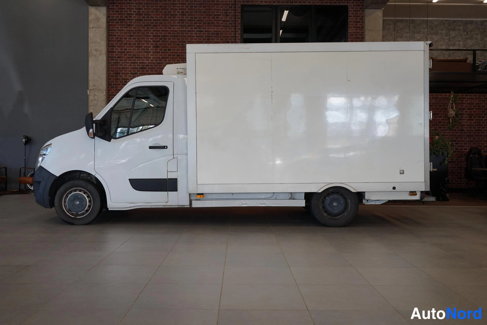 Etuviisto, nokka vasemmalle: Pakettiauton kylki ja keula valokuvassa: valkoinen Nissan-pakettiauto umpikorilla, kylkinäkyvä kolme neljännestä keula vasemmalla.