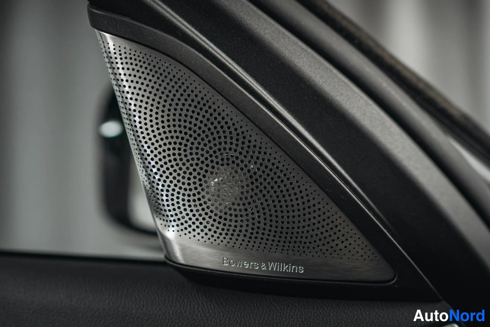 Yksityiskohta: Autoritratto interno di uno speaker con griglia perforata e marchio Bowers & Wilkins.