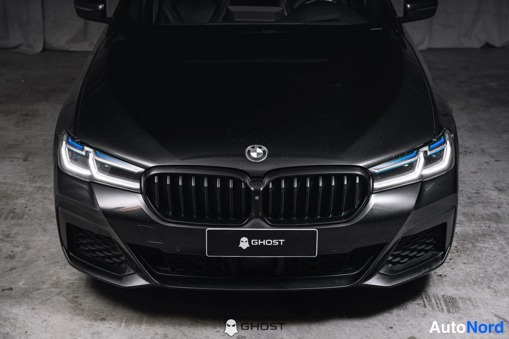 Edestä: Lähikuva mustan BMW:n konepeltua, etusäleikköä ja LASER-valoja.