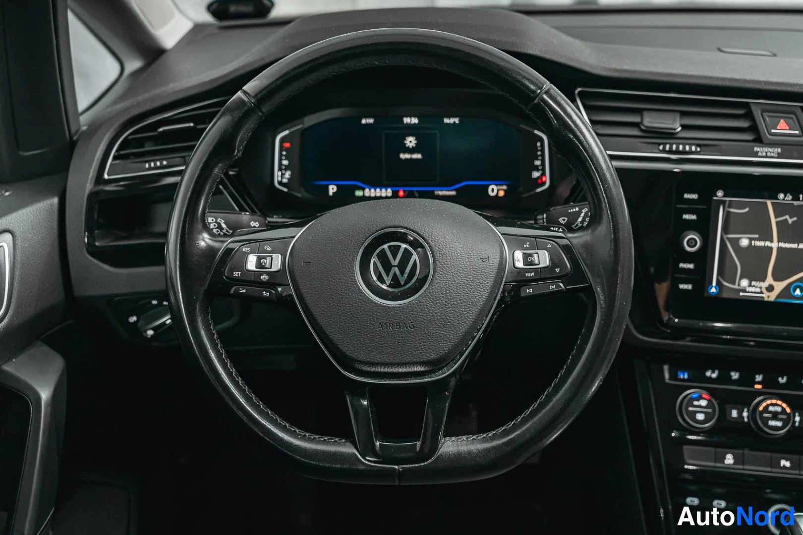 Muu: VW-merkkinen ohjauspyörä ja digitaalinen mittaristo lähikuvassa.
