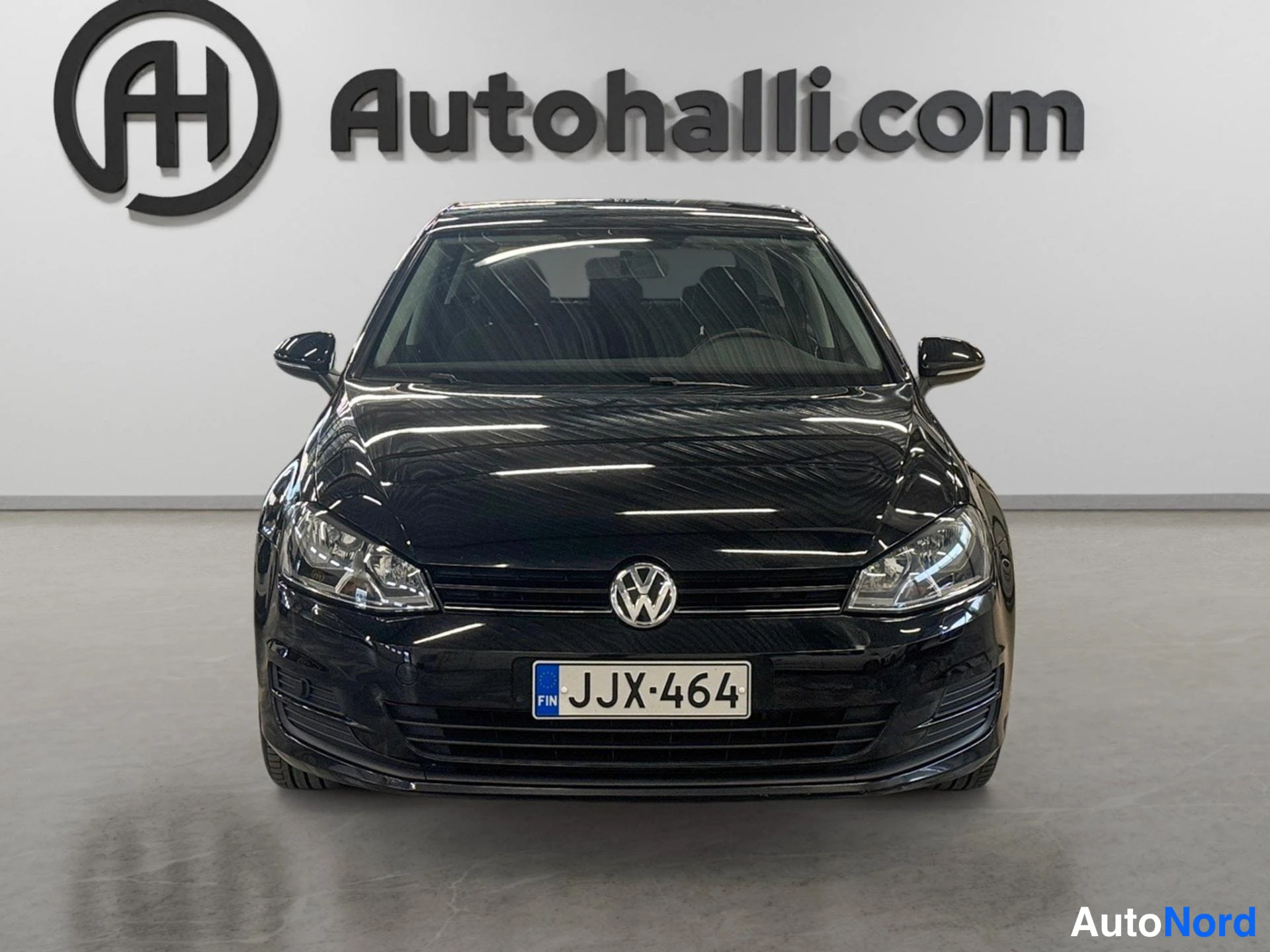 Edestä: Mustan Volkswagen Golf -henkilöauton suora etukuva, rekisterikilpi.