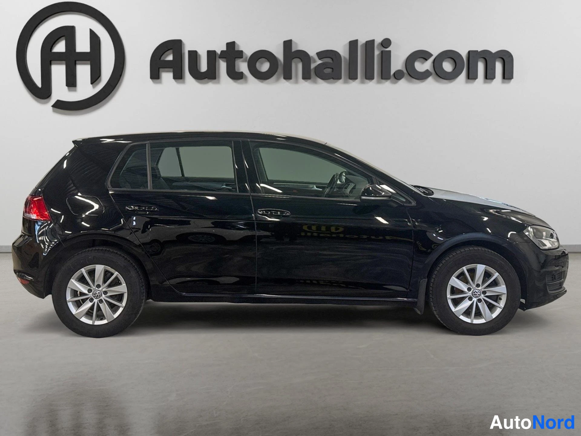Sivulta: Mustan Volkswagen Golf -henkilöauton sivukuva vasemmalta