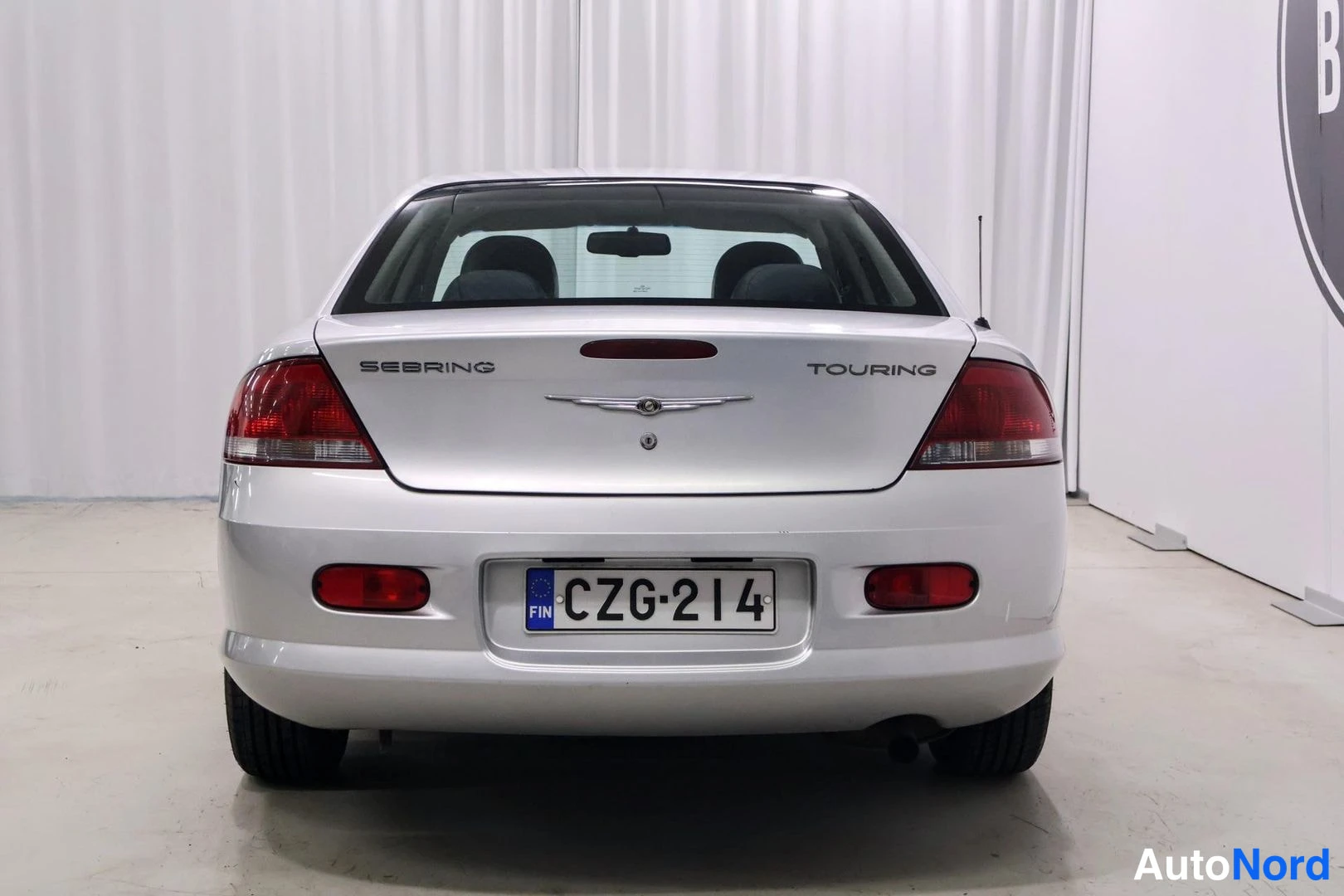 Takaa: Auton takaosa suoraan takaa; kannessa tekstit SEBRING ja TOURING, rekisteritunnus