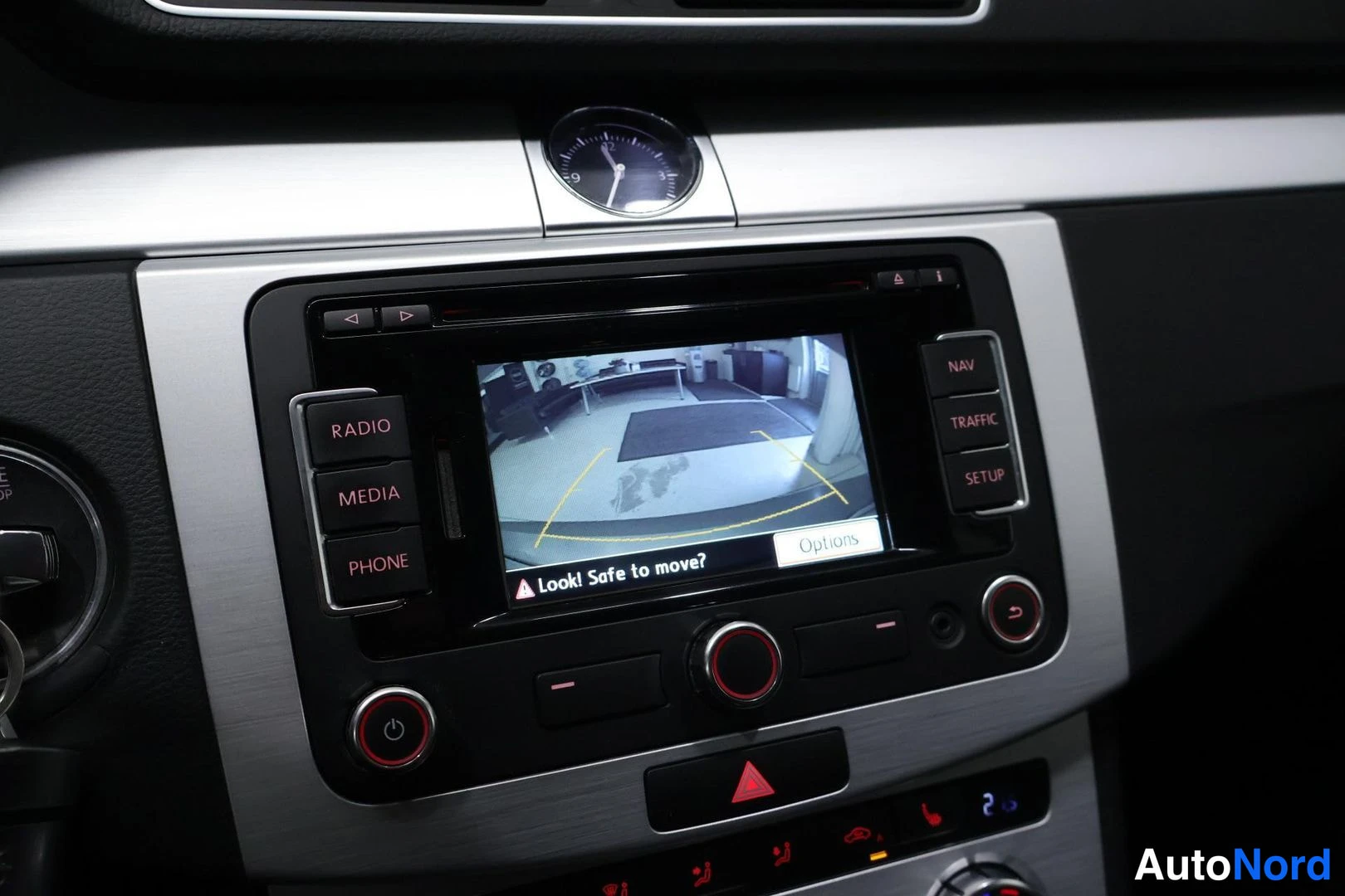 Muu: Keskikonsolin radio-näyttö näyttää peruutuskameran kuvaa ja varoituksen 'Look! Safe to move?'. Napit RADIO, MEDIA, PHONE, NAV, TRAFFIC, SETUP. Välittömästi koje